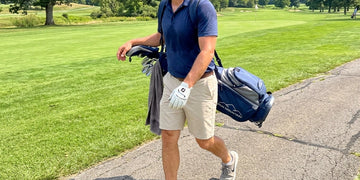 Golfer walking a sunny course with hot weather golf accessories.
