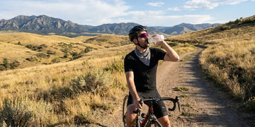 Cyclist drinking water during outdoor exercise to stay hydrated in hot weather