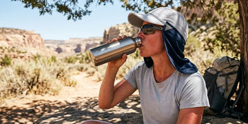 Person drinking water during a hot summer day to prevent dehydration.